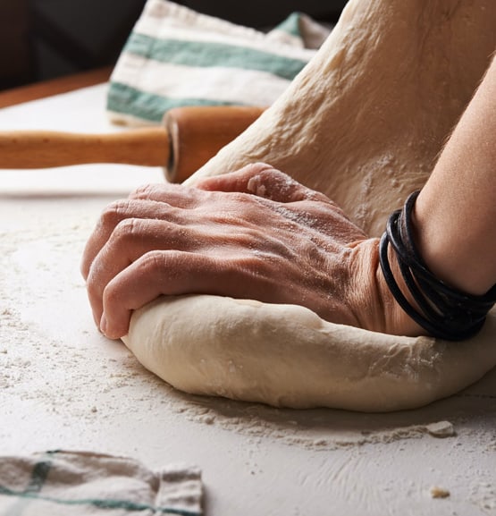 hands kneading fresh pizza dough